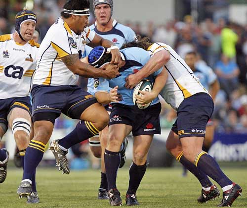 The Waratahs' Benn Robinson is tackled by the Brumbies' defence