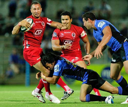 The Reds' Quade Cooper is tackled by the Western Force defence