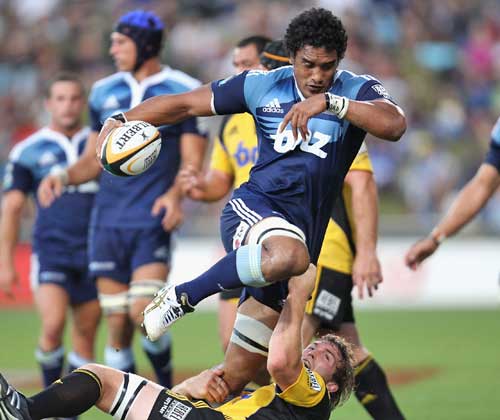 The Blues' Jerome Kaino is tackled by the Hurricanes' Jason Eaton