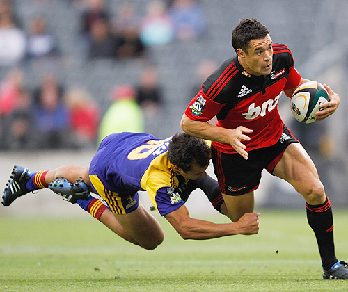 The Crusaders' Dan Carter is tackled by a flying Highlander in Matt Berquist
