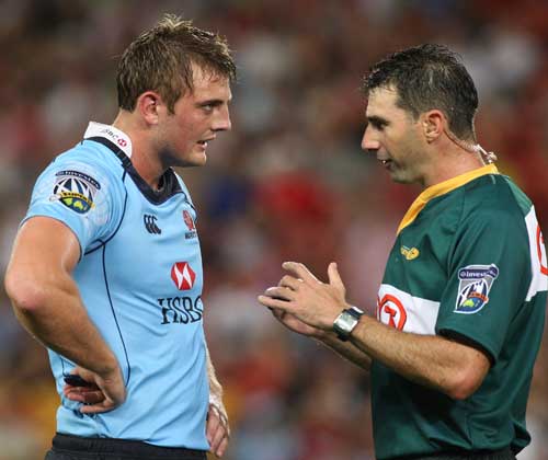 Dean Mumm talks to the referee before being yellow carded