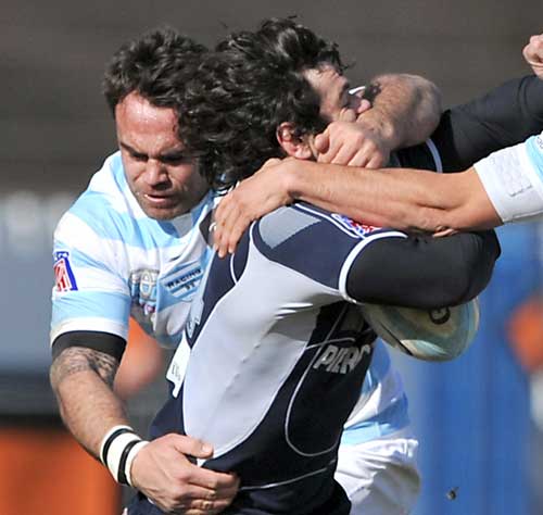 Castres' Marc Andreu is tackled by the Racing Metro defence 