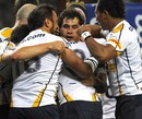 The Brumbies' George Smith is engulfed by his team-mates after scoring