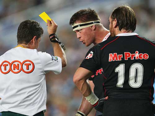 Referee Paul Marks shows a yellow card to the Sharks' Andy Goode