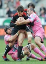Toulouse's Yannick Jauzion is tackled by the Stade Francais defence